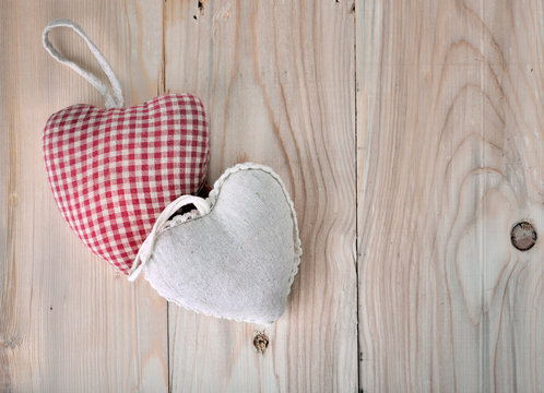 two little heart-shaped pillow on a plank 
