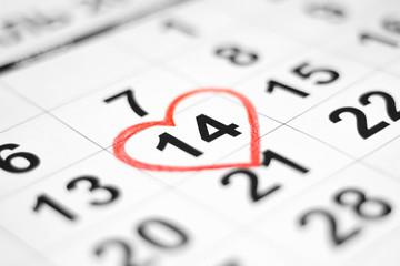 Valentines day and Holidays concept - Calendar sheet with 14th february date marked by red heart...