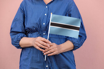 Botswana flag. Close up of a woman's hands holding Botswana flag.