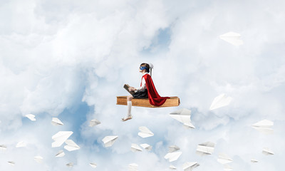 Girl power concept with cute kid guardian against cloudscape bac