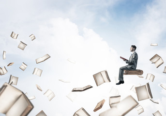 Man reading book and many of them flying in air