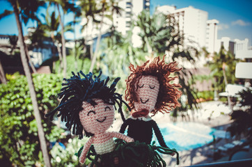 Two wool puppets in front of a typical resort vew in Honolulu, Hawaii