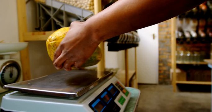 Male staff weighing papaya on weighing machine 4k