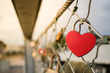 Heart-shaped love lock hanging on a bridge.. Valentine's Day background