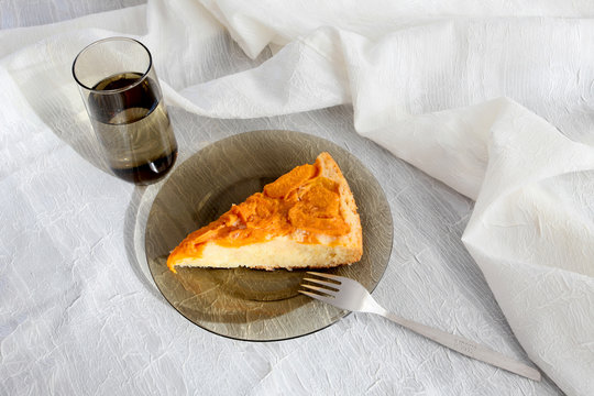 Cake with apricot compote and a glass of water. Homemade delicious breakfast.