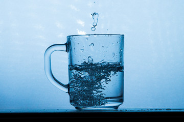 Naklejka na ściany i meble Water splashing from a glass