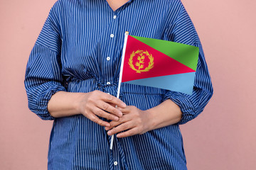 Eritrean flag. Close up of a woman's hands holding Eritrea flag.