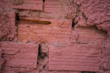 Red Bricks on Rough Wall. Not Properly Sealed with  Mortar Creating Irregular Gaps in Between. Messy Adobe Installation. Dirty Masonry Work of Bricklaying