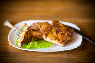 pork fillet chop fried in batter, in a plate