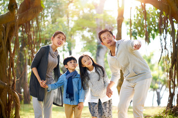 asian family with two children having fun in park