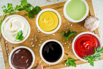 Set of classic sauces on white stone concrete stone background.