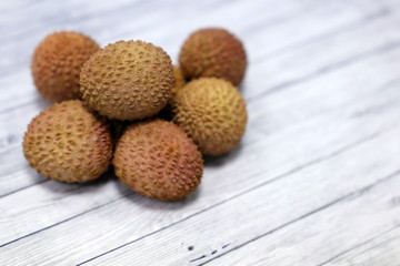 Ripe lychees on a wooden table. Fresh harvest of exotic fruit lychee