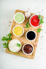 Set of classic sauces on white stone concrete stone background.