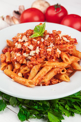 Pasta with meat, tomato sauce and vegetables on the table