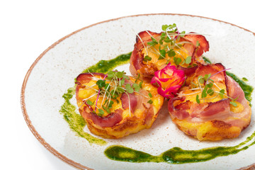 plate of bacon wrapped scallops in neat rows on a light colored plate