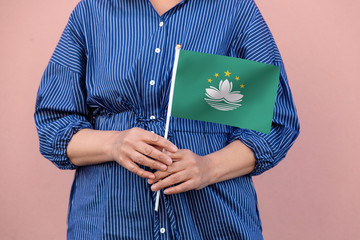 Macau flag. Close up of woman's hands holding Macau flag.