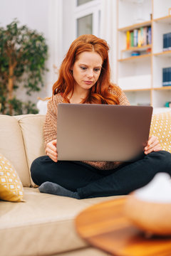Woman sitting on a couch with laptop