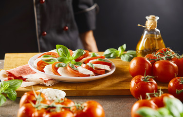 Chef looking at a fresh Caprese salad
