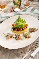 Fried chicken fillets, tomatoes and pineapples on white plate served on the table