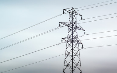 An electrical pylon against a grey overcast sky