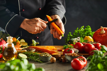 Chef slicing fresh carrots for a salad - obrazy, fototapety, plakaty