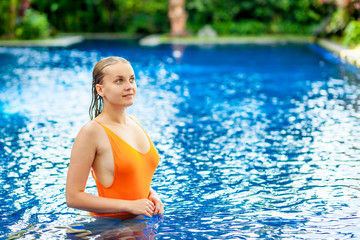girl with wet hair swimming in the pool