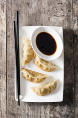Dumplings or gyoza with soy sauce on wooden table. Top view