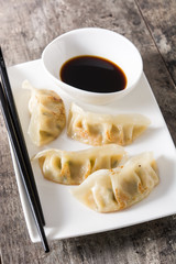Close up dumplings or gyoza with soy sauce on wooden table