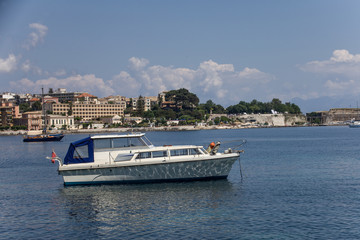 Obraz premium SideView Shot of Unmanned Double Deck Boat on Water under Cloudy Blue Sky. Establishments, Structures and Trees as Background. Vacation Destination Ideas