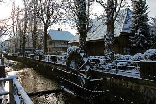 snow covered water mill in the center of Lyss, Switzerland.