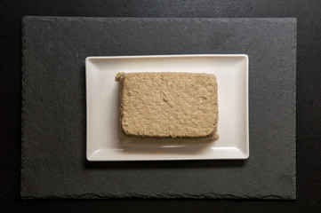 Flat lay. Close up. Japanese food. A piece of tofu, a protein-rich soy cheese, on a white...