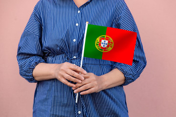 Portugal flag. Close up of a woman's hands holding Portuguese flag.	