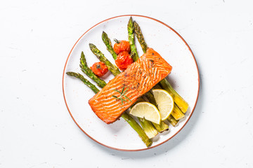 Grilled salmon fish fillet with asparagus on white. 