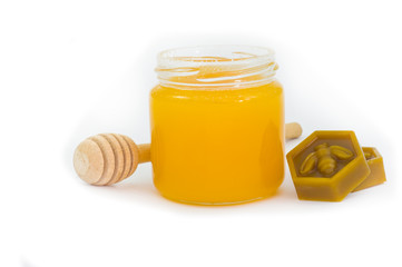 Jar of honey, wax and wooden dipper