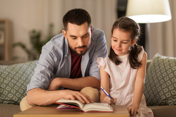 education, family and homework concept - happy father and daughter with book doing homework at home