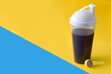 Chocolate protein shake on yellow and blue background. Copyspace