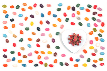 Jelly bean sweets background with a heart gift box