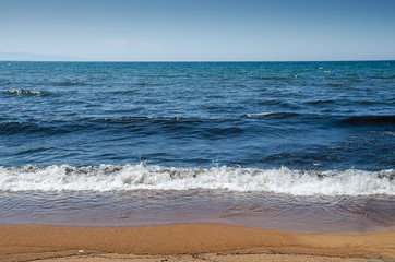 Fototapeta na wymiar Soft Wave Of Blue Ocean On Sandy Beach. Background.