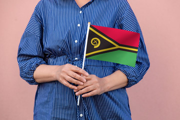 Vanuatu flag. Close up of a woman's hands holding Vanuatu flag.	