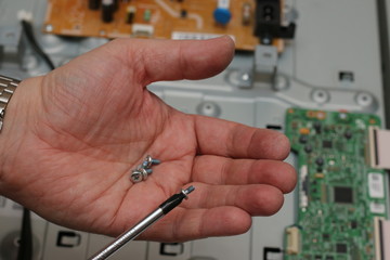 man holding a screwdriver and screws repair tv or pc. fix electrical circuit chip