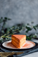 Piece of chocolate and walnut cake on a plate on a table.