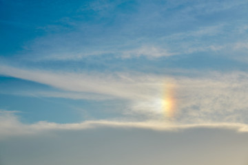 Blue cloudy sky with rainbow effect as a natural background. 