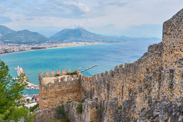 Medieval wall in Alanya, Turkey with cloudy sky.