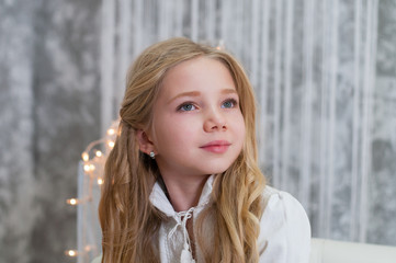 Obraz premium Happy smiling child girl with blond hair looks away