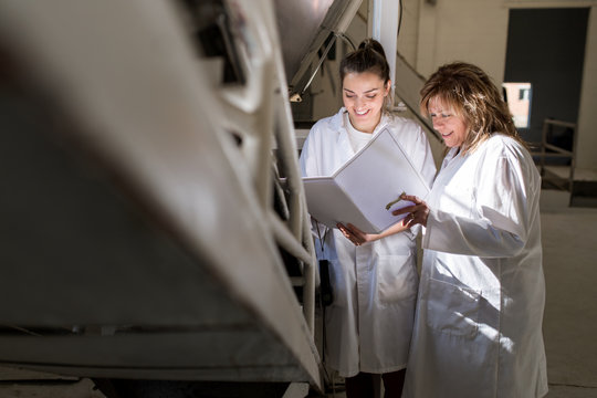 Two women with white coat working in a factory