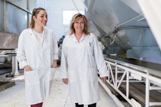 Two women with white coat working in a factory - Powered by Adobe