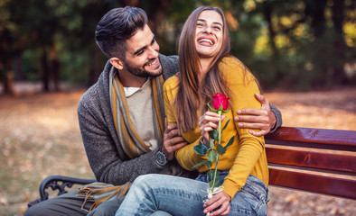 Meeting in the park. Young man surprised his girlfriend with a red rose. Love, dating, romance