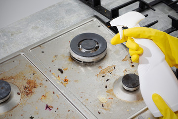 Cleaning a gas stove with kitchen utensils, household concepts, or hygiene and cleaning.