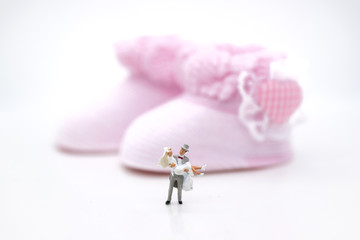 Miniature people : Bride and groom wear wedding suit and waiting for baby in the future . Image use for make new family.