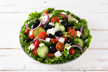 Fresh Greek salad in Plate with black olive,tomato,feta cheese, cucumber and onion on gray...